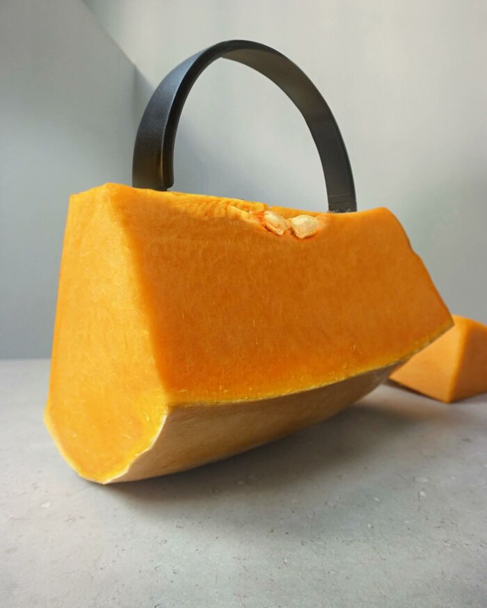 Illusion art by Dudi Ben Simon: a pumpkin slice resembling a handbag with a black handle.