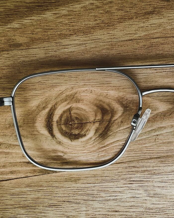 Illusion art by Dudi Ben Simon: Eyeglasses frame highlighting a wood grain resembling an eye.