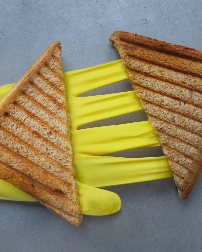 Grilled sandwich illusion with yellow gloves, showcasing artistic fusion.