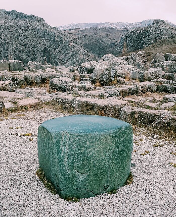 Iconic rocky landscape with a prominent weathered green stone in the foreground, showcasing awe-inspiring natural beauty.