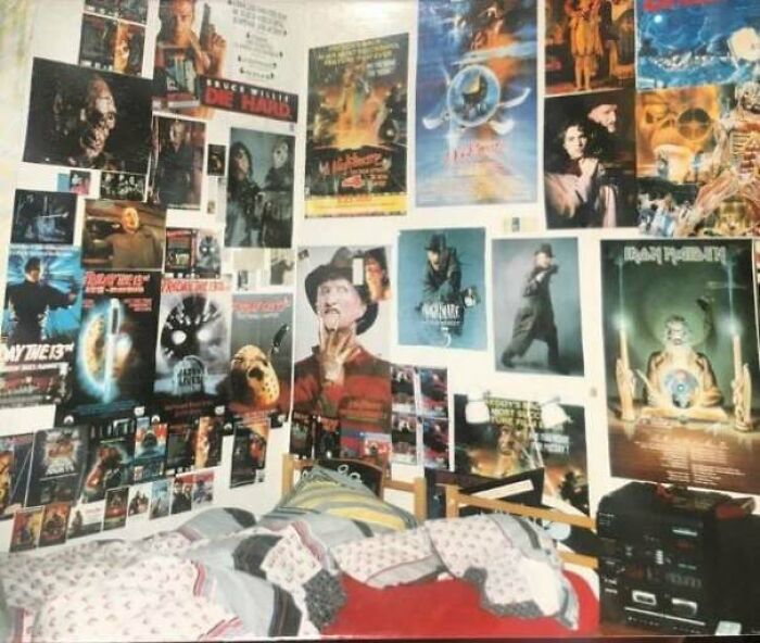 1980s vibe room with movie posters covering the walls above a bed, reflecting popular culture of the era.