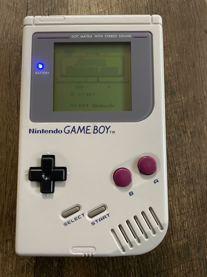 1980s vibe captured by a classic Nintendo Game Boy displaying "Super Mario Land" on its screen.