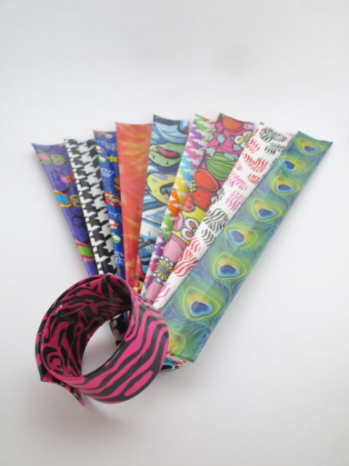 Colorful 1980s slap bracelets with various patterns on display, including zebra stripes and peacock feathers.