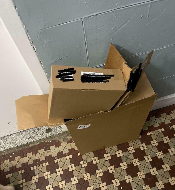 Cardboard boxes left in a hallway, showcasing a passive-aggressive encounter with unclear delivery details.