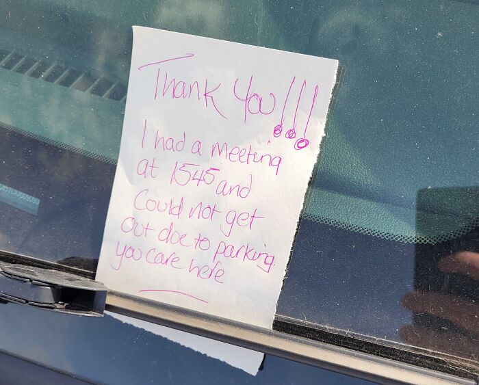 A passive-aggressive note on a car windshield about parking inconveniences and a missed meeting.