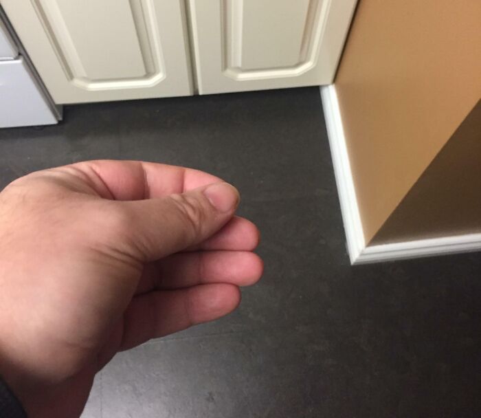 Mano haciendo un gesto en cocina, detalle ingenioso en la vida cotidiana.