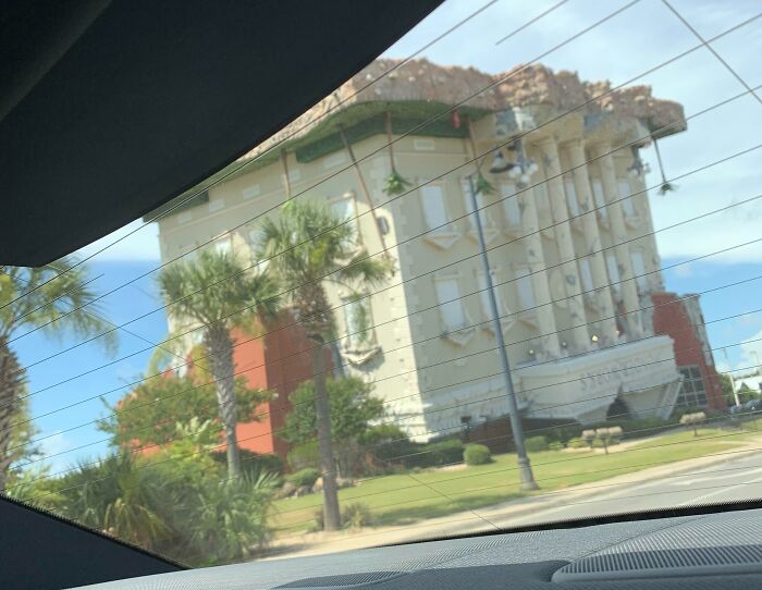 Iconic WonderWorks building in Orlando, an awe-inspiring architectural marvel flipped upside down, seen through a car window.