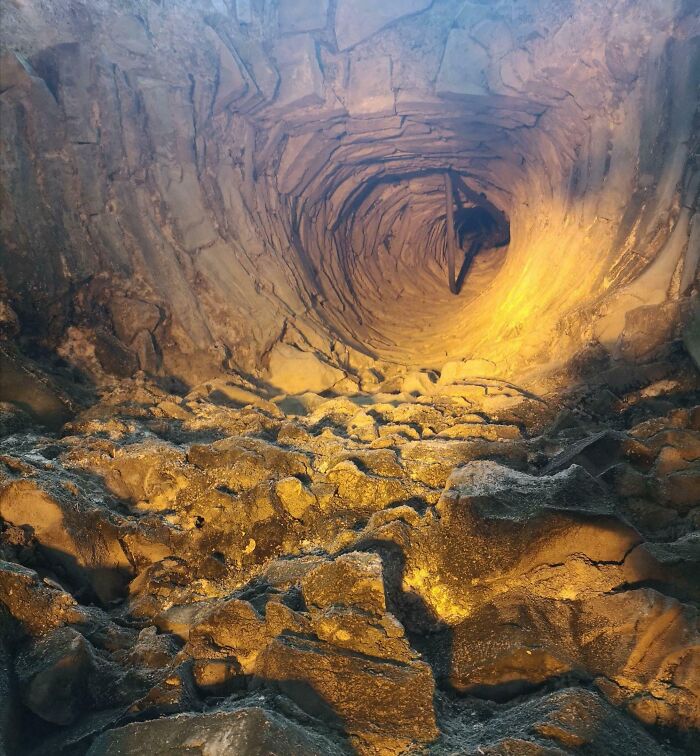 Awe-inspiring cave ceiling formed by natural rock formations with golden lighting.