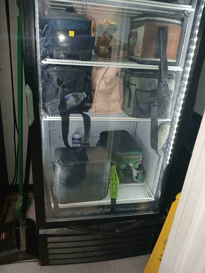 Lunch bags stored incorrectly in a workplace fridge, showcasing worst colleagues' habits.