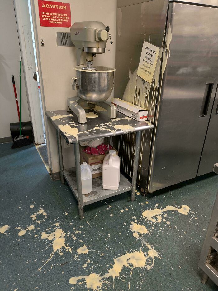 Mixer overflow in kitchen causing messy spill, signaling a worst day at work with batter on floor and counter.