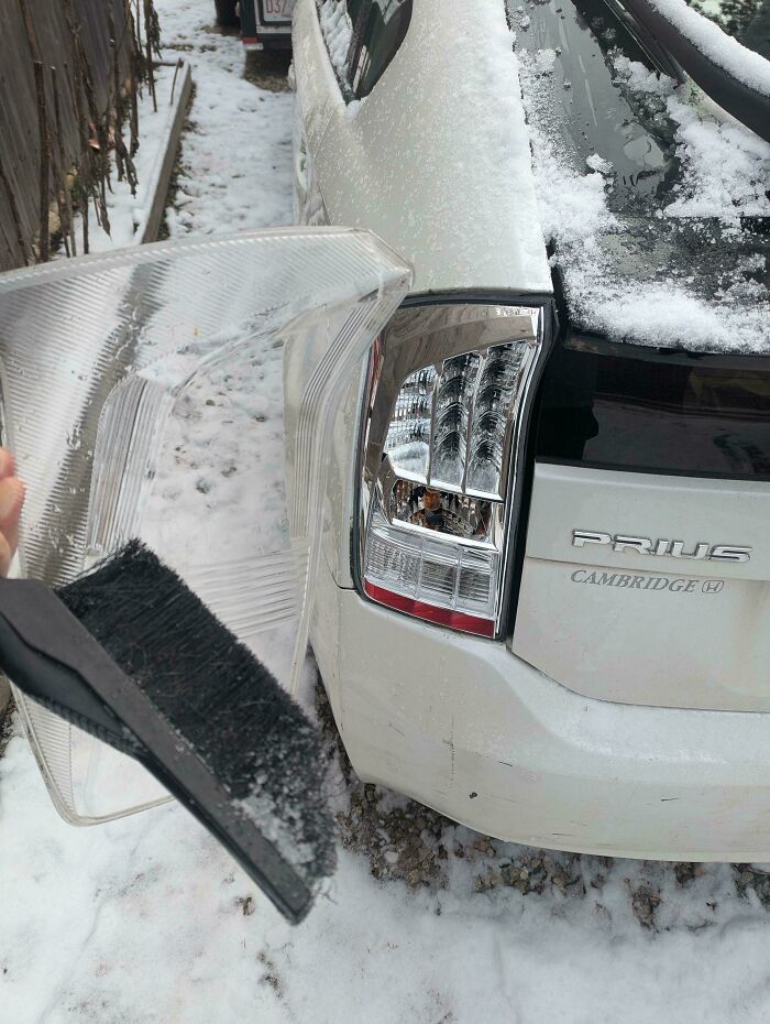 Broken rear car light from snow brush accident, illustrating a bad day at work scenario.