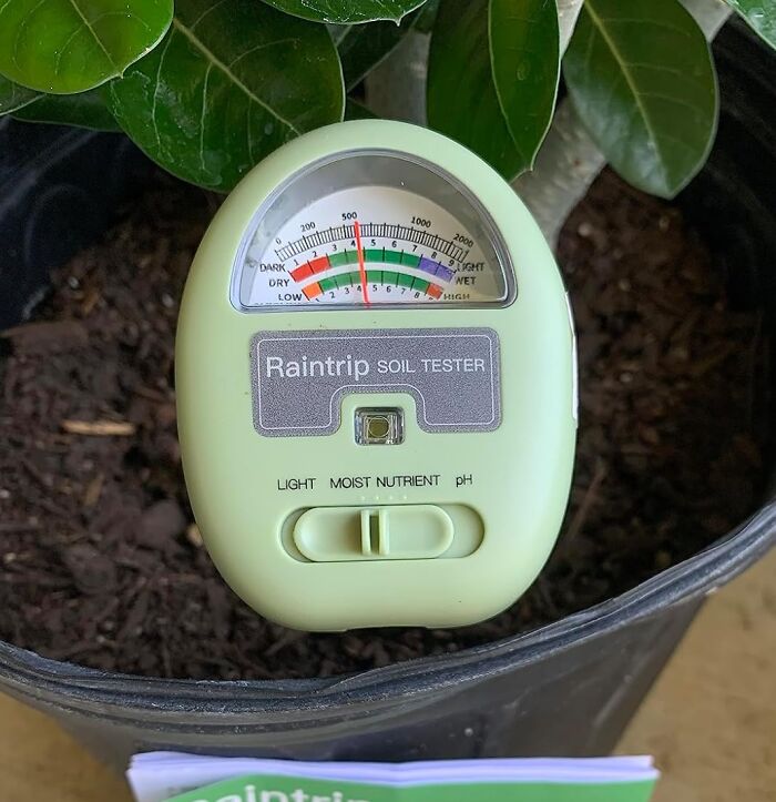 Soil tester for garden care, measuring light, moisture, and pH levels in a plant pot.