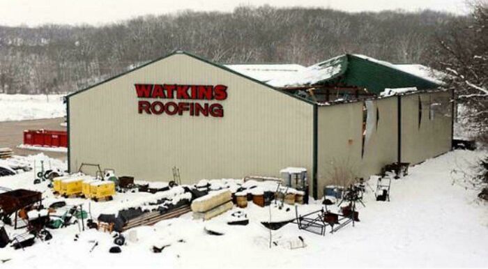 Watkins Roofing building damaged by a significant accident in winter, with snow covering debris. Looks expensive.