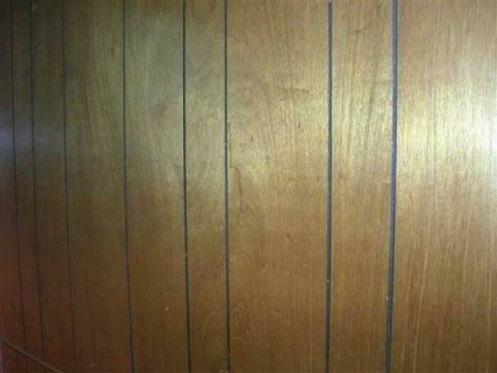 Wood-paneled wall close-up, evoking nostalgic vibes from people realizing they are old now through vintage aesthetics.