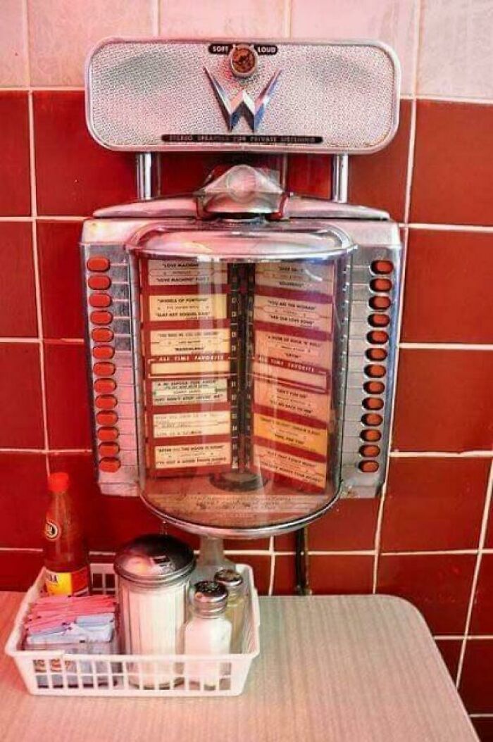 Vintage tabletop jukebox with song selection cards and condiments on a retro diner table nostalgic pics from people who are old now