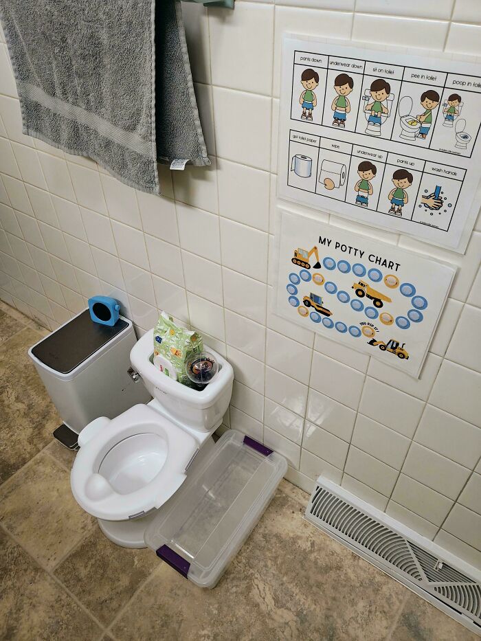 Child-friendly bathroom setup with potty training chart and visual guides, showing dads doing their best parenting moments.