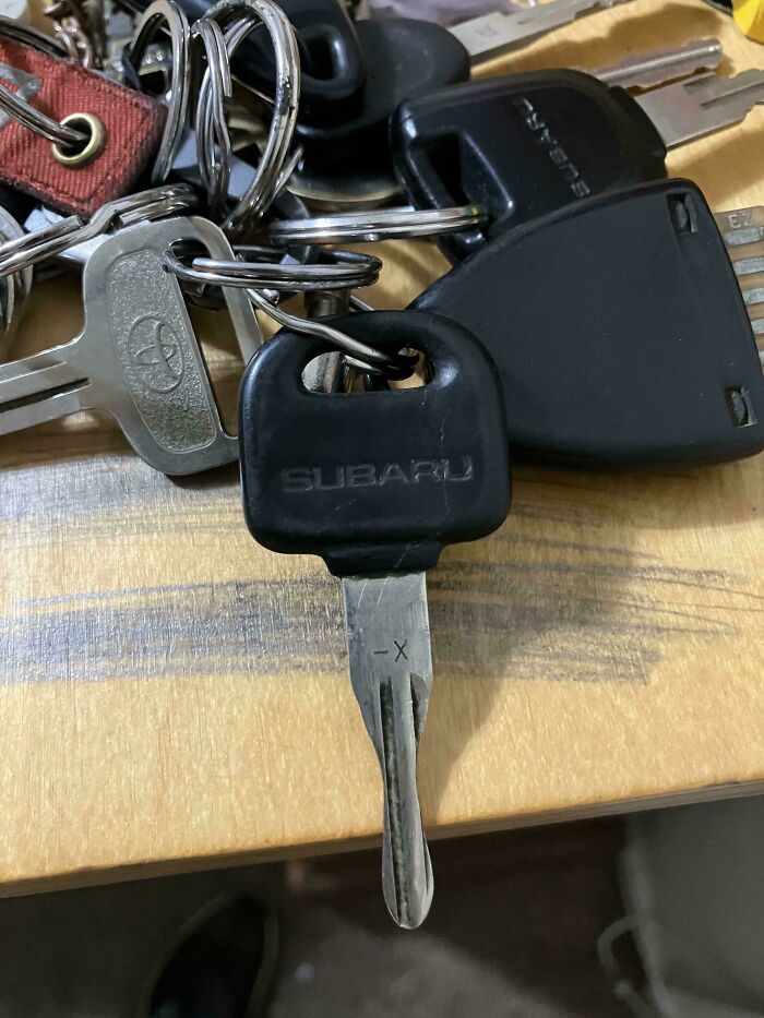 Llave de automóvil con signos de desgaste por el tiempo sobre una mesa de madera.