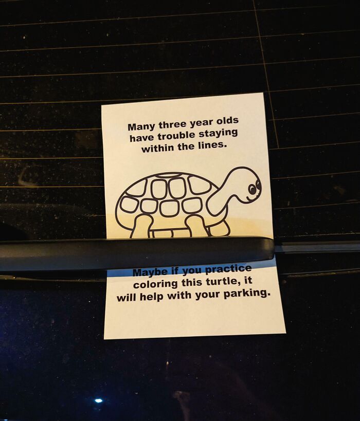Funny passive-aggressive note on a car with a turtle drawing, suggesting better parking skills.