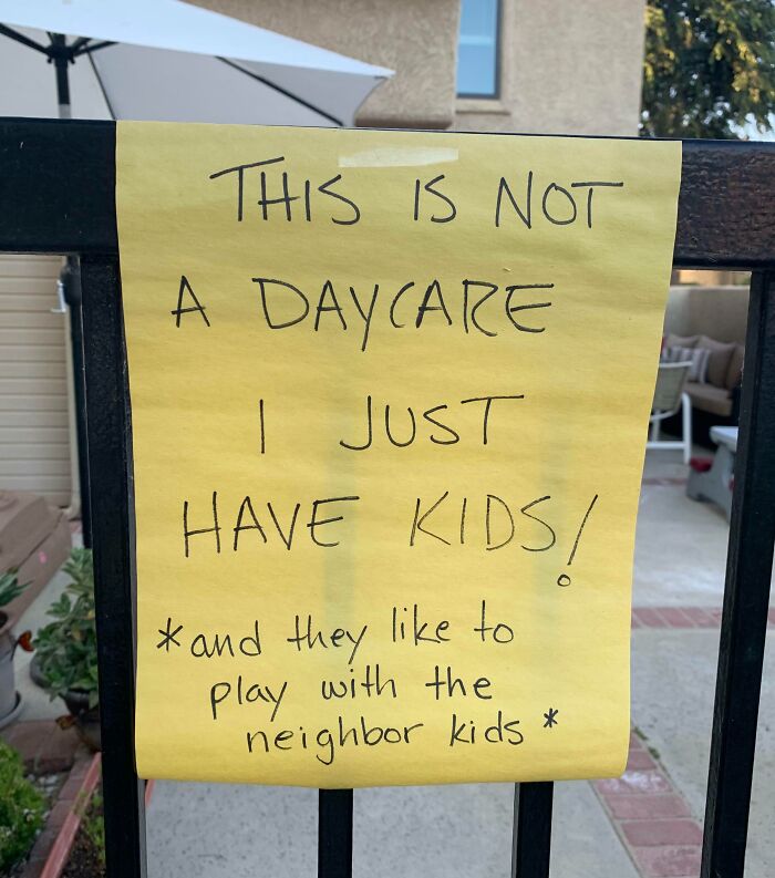Yellow sign on fence humorously clarifying it's not a daycare, referencing passive-aggressive encounters.