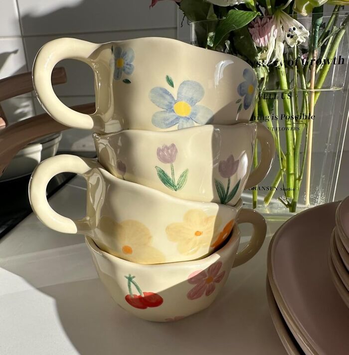 Stacked floral mugs in sunlight, a new find adding charm to any kitchen collection.