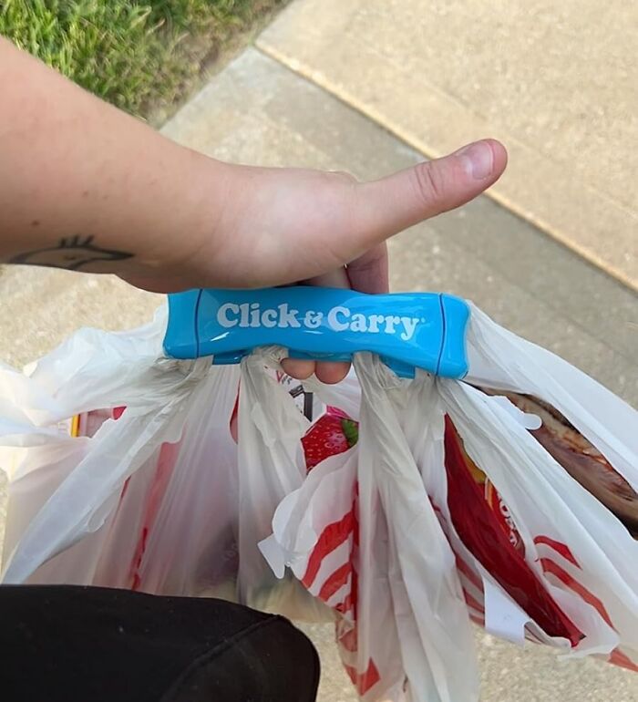 Person holding a Click & Carry handle with multiple grocery bags, showcasing one of the new finds.