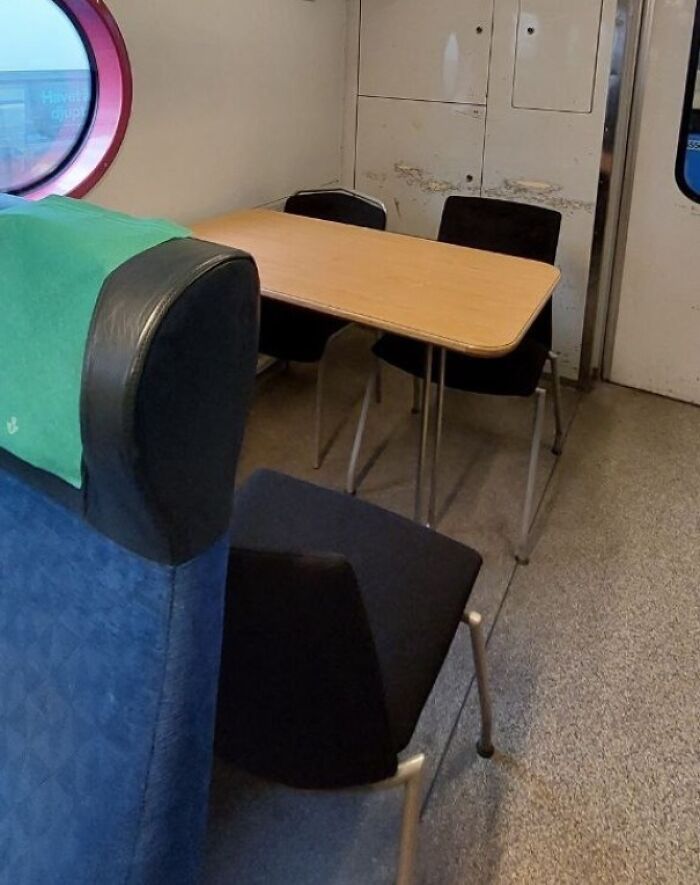 Train seat turned into a makeshift office with a table and chairs, creatively using space by acting like they belong.