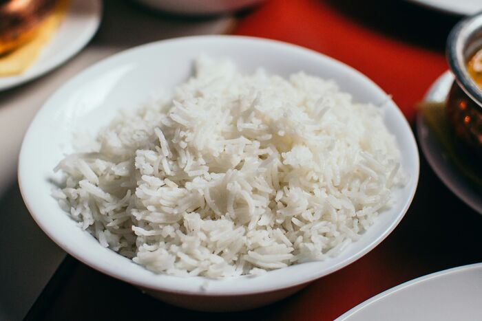 A bowl of steaming white rice on a table, exemplifying simple approaches to enhance daily life.