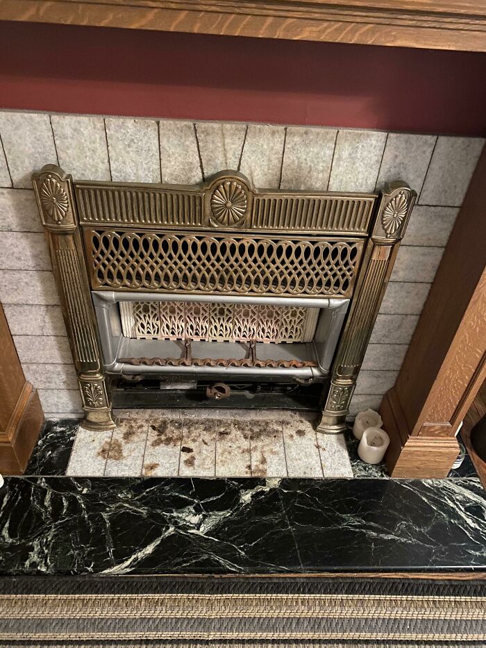 Antique metal fireplace with ornate design found in an old house.