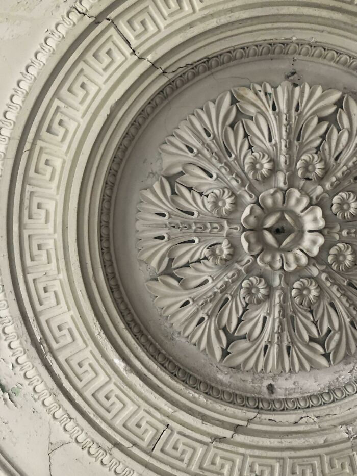 Ornate ceiling medallion with intricate patterns found in an old house, showcasing historical artifacts.