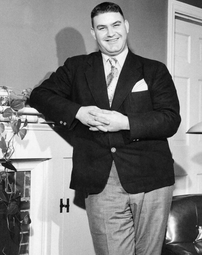 A man confidently posing in a suit, exemplifying acting like they belong in a formal setting.