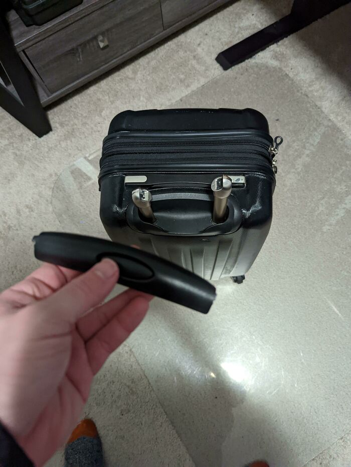 Broken suitcase handle detached from luggage, exemplifying an epic airline baggage fail.