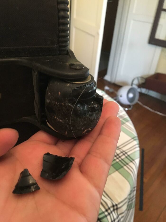 Broken airline baggage wheel held in hand, showcasing an epic baggage fail.