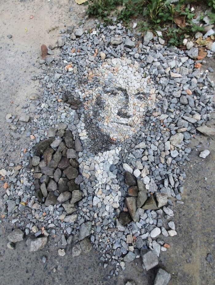 Intricate mosaic of a face created from stones and pebbles, showcasing British artist's skill in temporary art.
