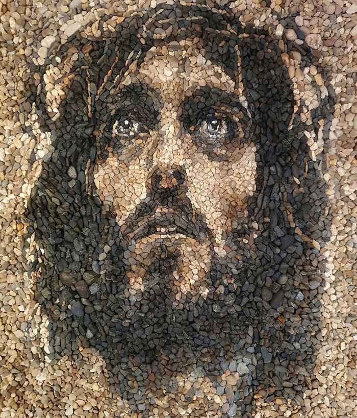 Intricate mosaic portrait using stones and pebbles by British artist, showcasing temporary art.