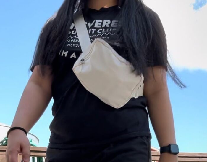 Person wearing a black shirt and white f***y pack, reminiscent of 80s fashion.