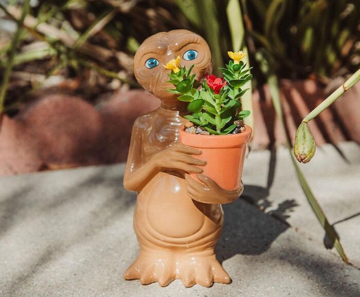 80s kids treasure figurine holding a small plant in a pot.