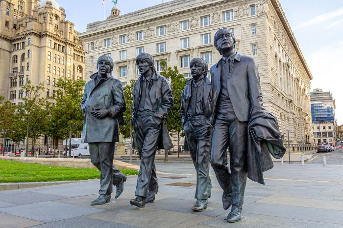 Statues of four figures walking together in Liverpool, capturing a historical turning point in music history.