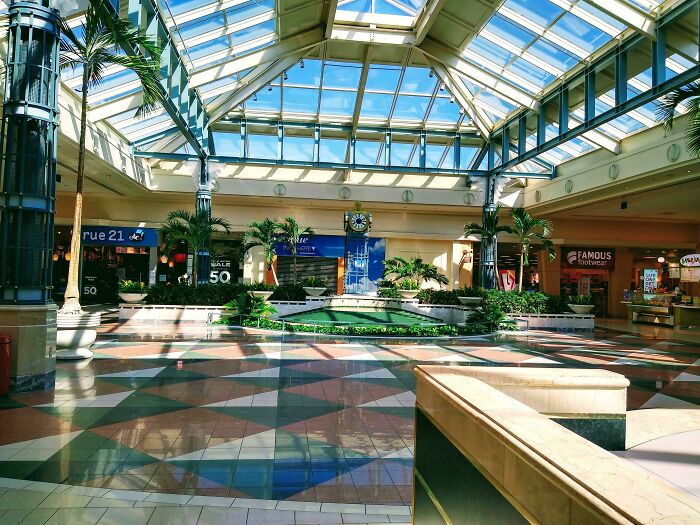 Vintage mall interior with skylights and food court signs, evoking nostalgic shopping experiences.