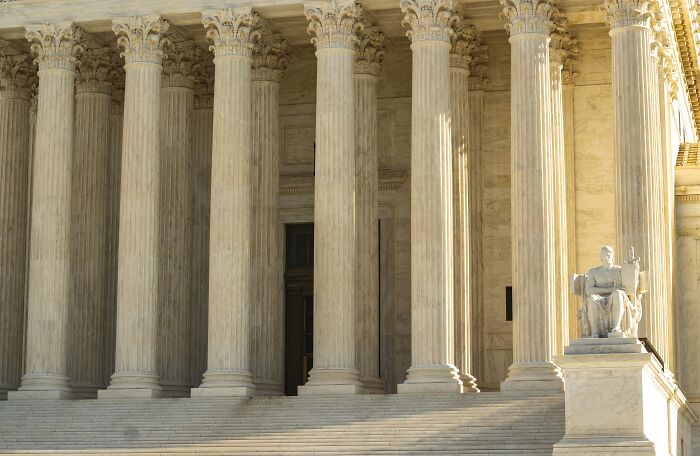 Historic courthouse with grand pillars and a justice statue, symbolizing significant turning points in history.