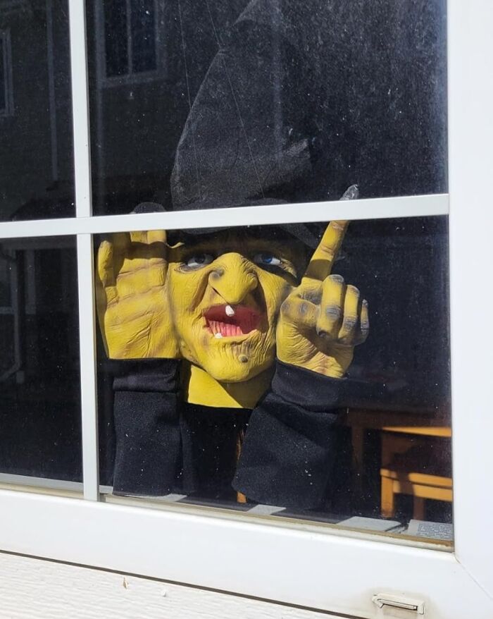 Funny April Fools prank with a yellow mask peeking through a window.