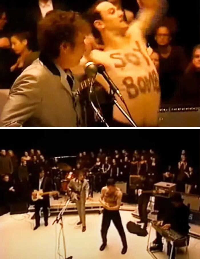 Shirtless man with "Soy B**b" on chest disrupts awards show performance, creating a scandalous moment on stage.