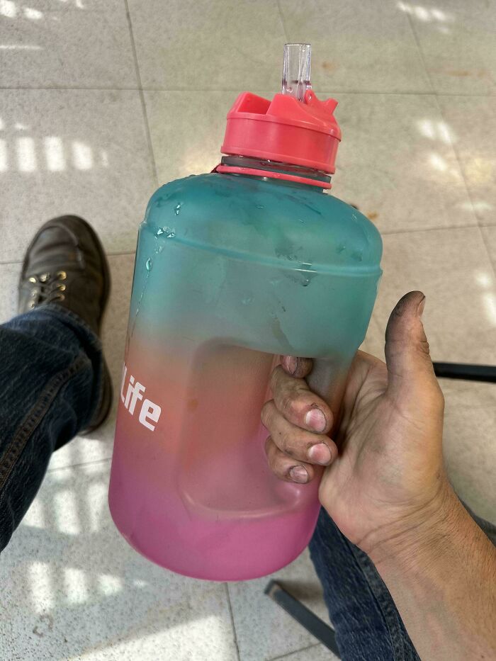 A person with dirty hands holding a colorful water jug marked "life," highlights worst colleagues' habits.