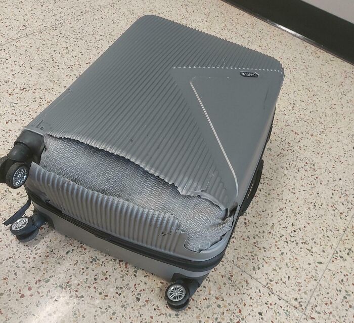 Damaged airline baggage with missing chunks and exposed interior, showing an epic baggage fail.