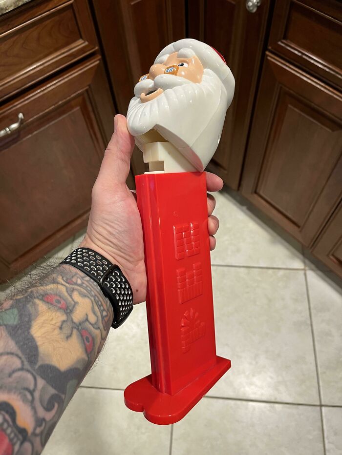 Hand holding a vintage Santa Claus Pez dispenser, a collectible item.