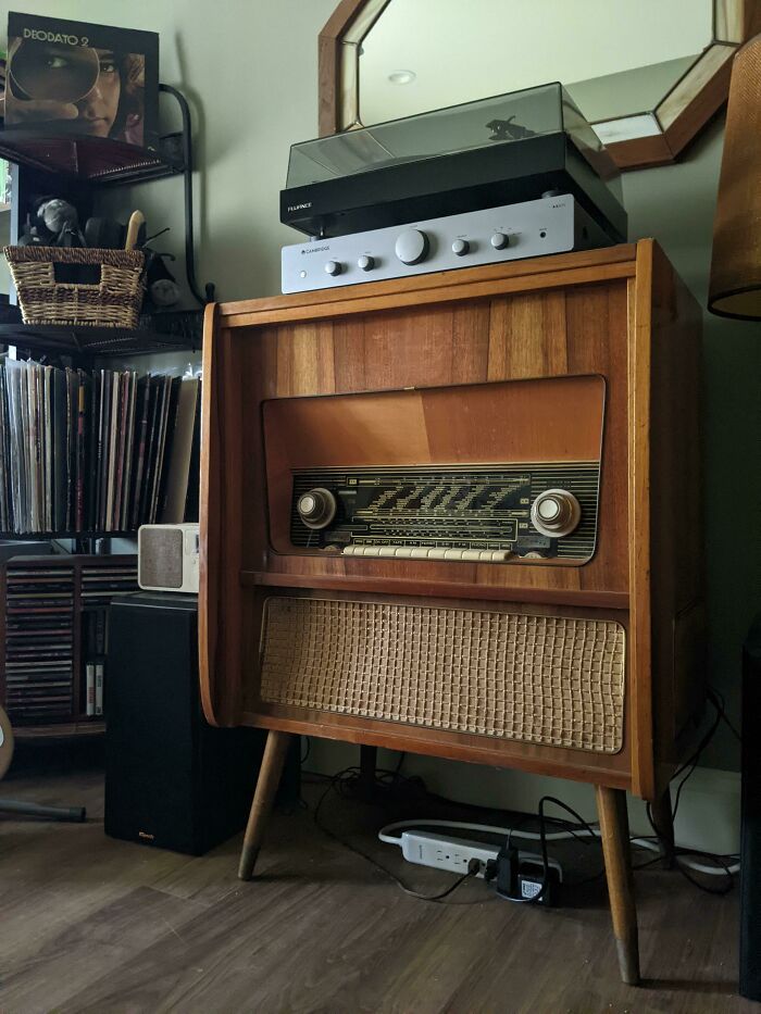 Vintage record player and radio console, surrounded by vinyl collections, showcasing classic design and valuable nostalgia.
