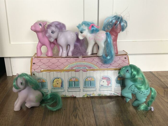 Vintage My Little Pony toys displayed on a table, featuring colorful figures with original carry case.
