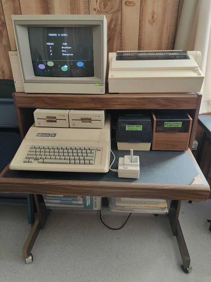 Vintage computer setup with monitor, keyboard, and floppy disk drives, showcasing retro technology.