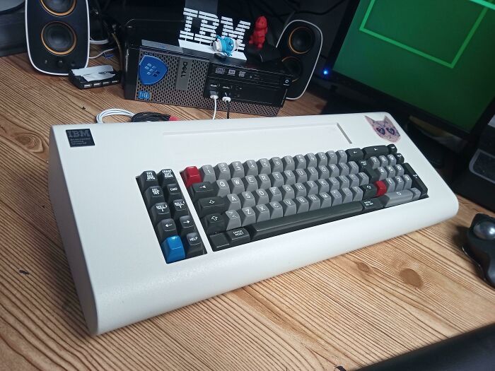 Vintage IBM keyboard on a wooden desk, showcasing retro computing equipment with classic design.