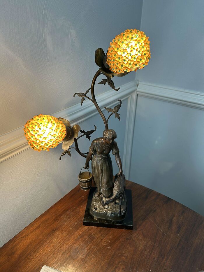 Vintage lamp with intricate design, featuring a detailed figure and ornate floral lights, valuable collectible.