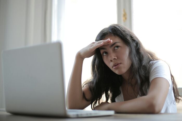 Person frustrated with overused office expressions while looking at a laptop.
